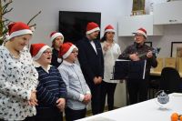 Uczestnicy ŚDS śpiewają kolędy przy akompaniamencie ukulele