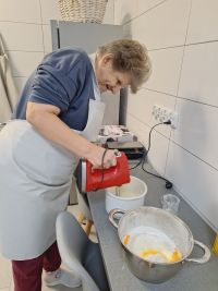 Uczesniczka ŚDS Małgorzata przygotowuje ciasto na gofry