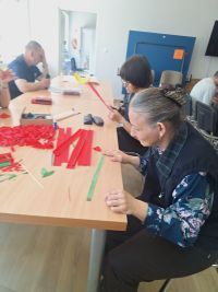 Uczestnicy ŚDS podczas przygotowania kwaiatów na dzien mamy.