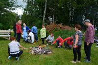 Pieczenie kiłbasek przez zuczestników pikniku w Bartnikach.