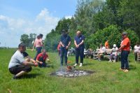 Uczestnicy ŚDS pieką kiełbaski na ognisku.